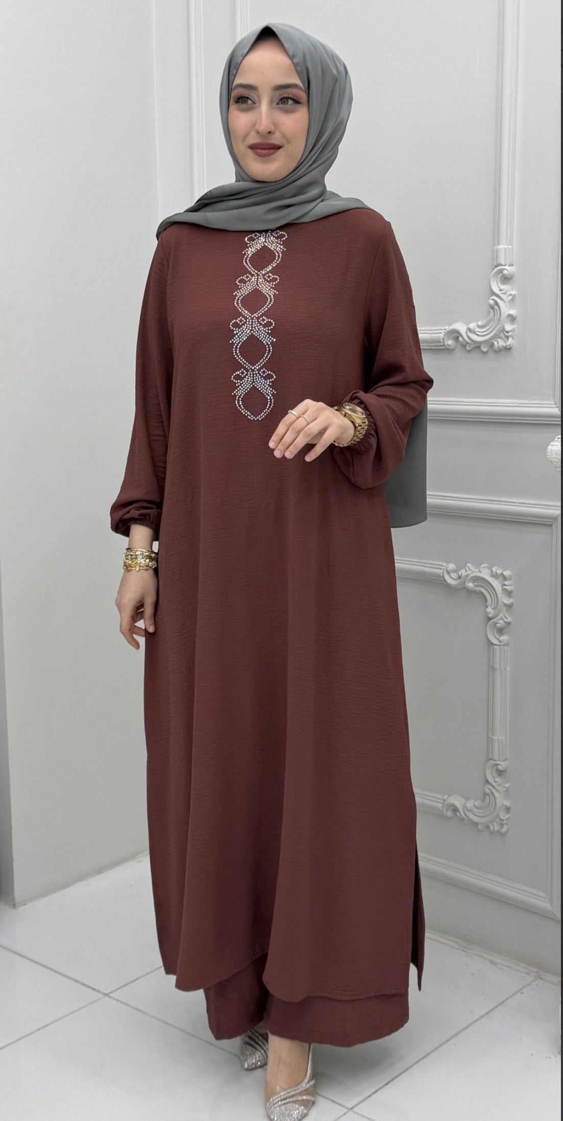 Woman wearing a navy blue embroidered abaya tunic and wide-leg pants set with a navy hijab
