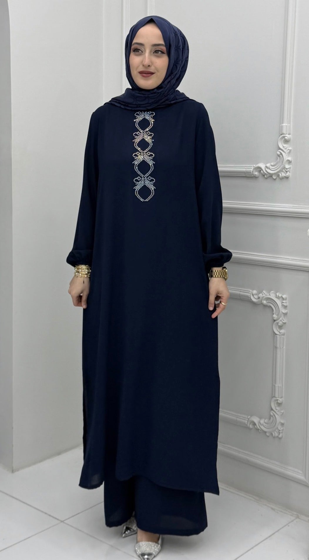 Woman wearing a chocolate brown embroidered abaya tunic and wide-leg pants set with a grey hijab